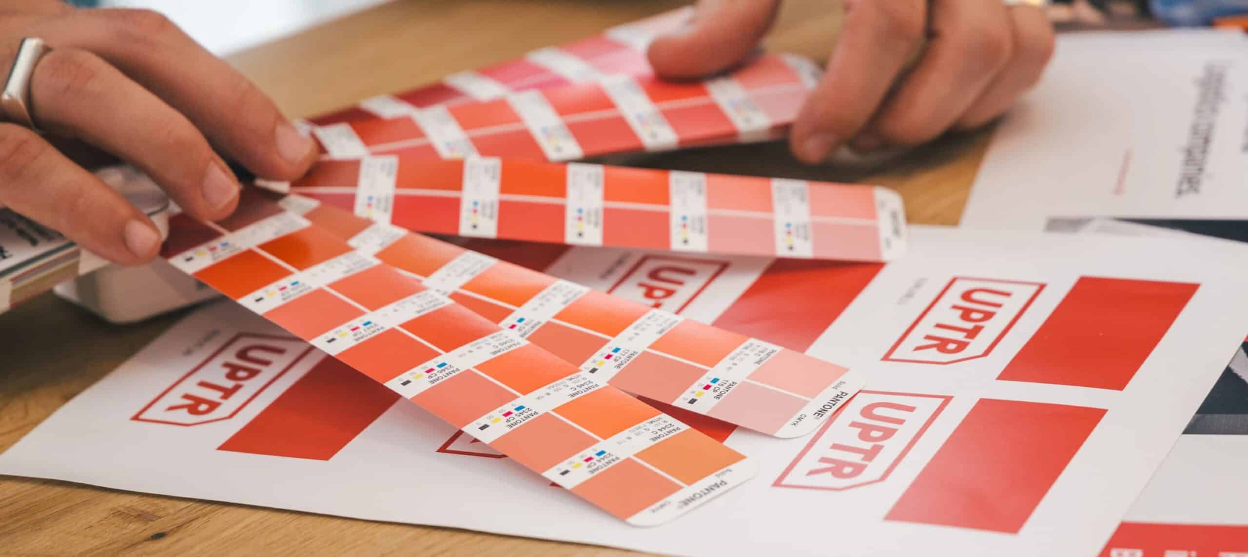 Picture of a man holding Pantone color swatch looking at red shades